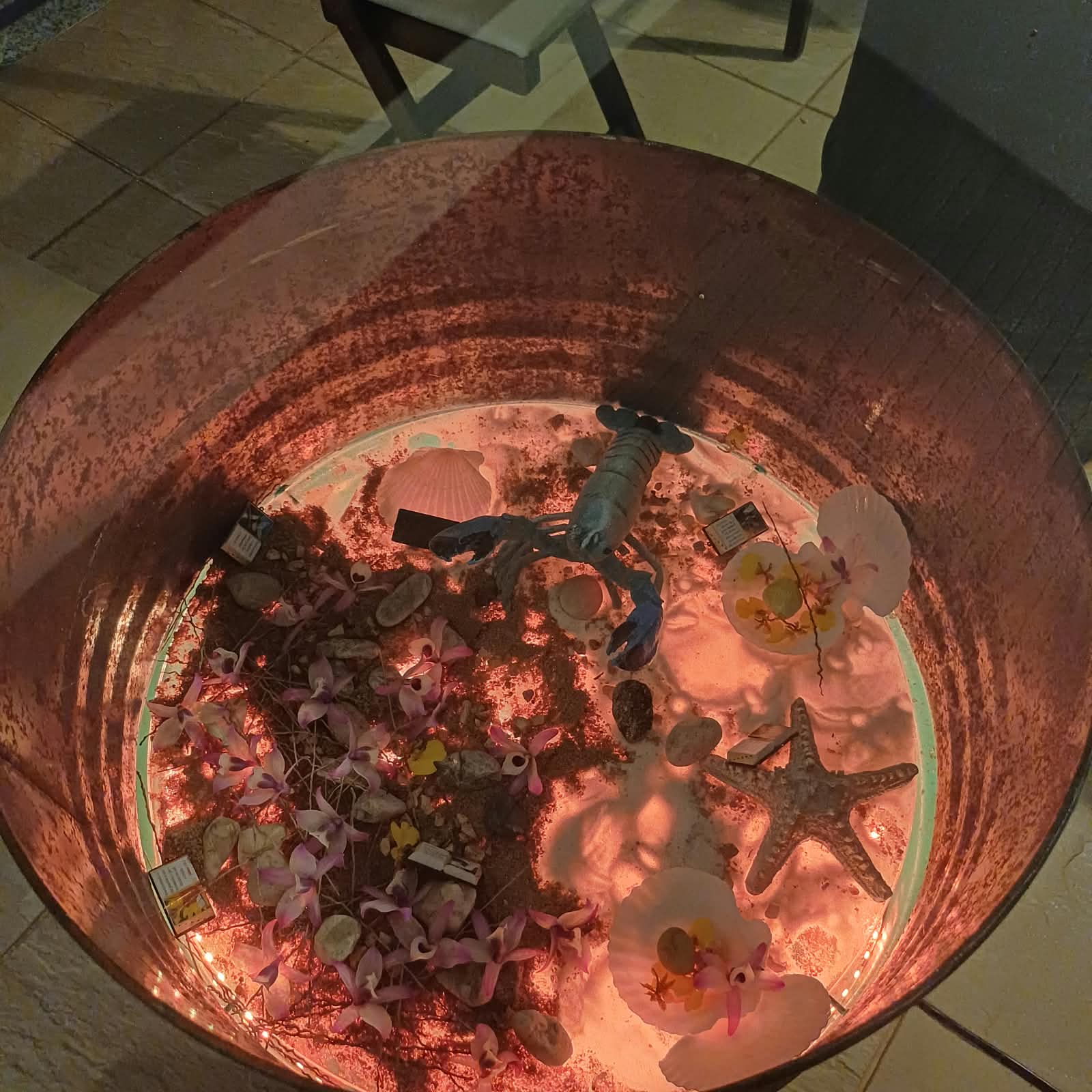 Mesa Kairós completa, com tampo de vidro sobre base de tambor, montada em um ambiente residencial